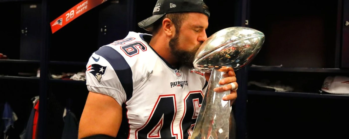 football player kissing a trophy