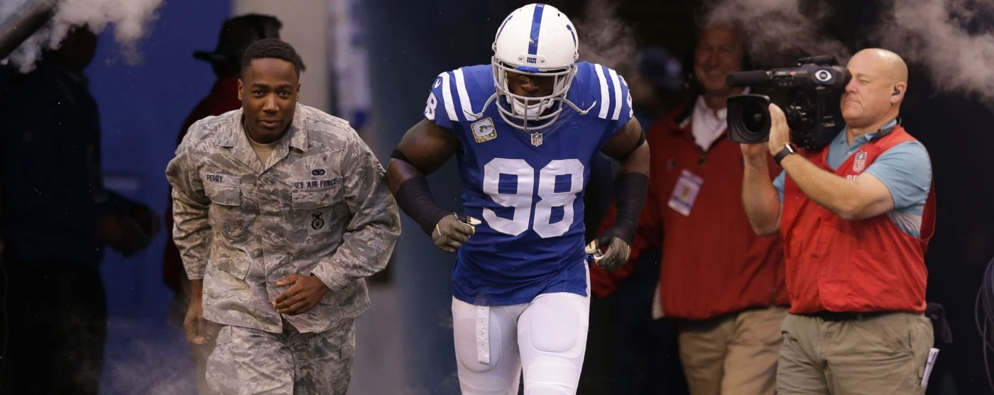 a football player running out on the field with a man in uniform